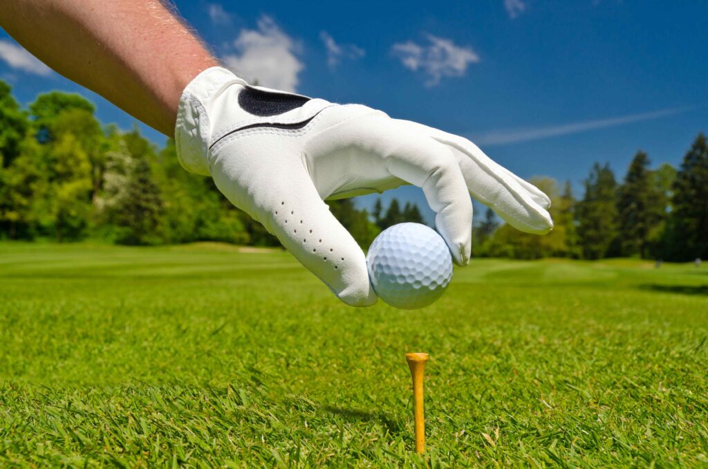 Golfer placing ball on tee
